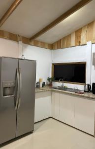 a kitchen with a stainless steel refrigerator and white cabinets at Cabaña 23 - private cabin in Montaña Azul