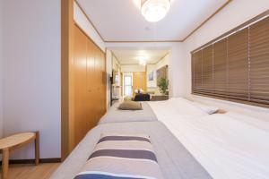 a bedroom with two beds and a large window at Cozy Nest Sangenjaya 1 Stop to Shibuya ーWalk to Sangenjaya and Ikejiri in Tokyo