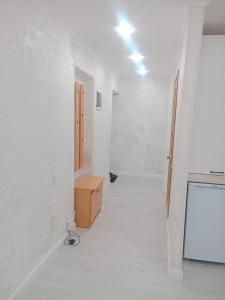 an empty room with a white wall and a wooden drawer at Металлург in Ustʼ-Kamenogorsk