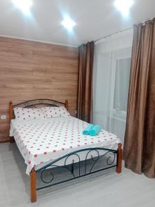 a bedroom with a bed with a polka dot mattress at Металлург in Ustʼ-Kamenogorsk