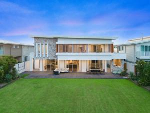a house with a large backyard with a lawn at Beachfront Wellness Retreat in Casuarina