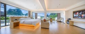 a large bedroom with a large bed and large windows at Mountain Search Snow View Hotel (Yangshuo Water Ink Landscape Store) in Yangshuo