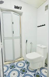a bathroom with a toilet on a tiled floor at IMAN Homestay in Melaka