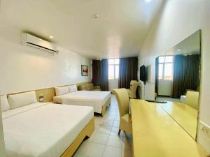 a hotel room with two beds and a couch at Hotel Pier Cuatro in Cebu City +28 photos