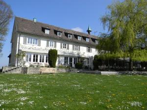 a large white building with a lawn in front of it at Hotel Landgut Burg in Weinstadt