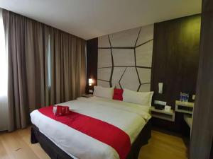 a hotel room with a large bed with red accents at Paragon Nagoya Hotel Batam in Nagoya +88 photos