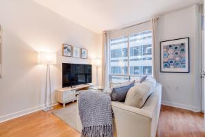 a living room with a couch and a television at 2BR Yorkville Condo - Self Check In & Free Parking in Toronto