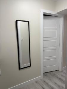 a mirror on a wall next to a closet at Newly Built Cozy Cove Suite in Regina