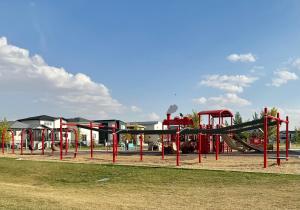 a playground with a slide in a park at Newly Built Cozy Cove Suite in Regina
