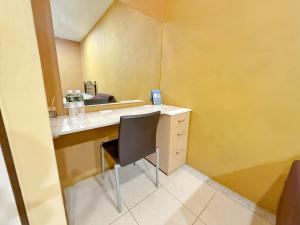 a bathroom with a desk with a chair and a mirror at Kinmen Wagui B&B in Jinning