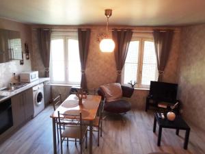 a kitchen and living room with a table and chairs at Les Petits Souliers in Lestrem