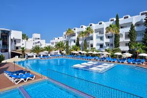 a hotel room with a pool, chairs, and a pool table at Sol Cala d´Or Apartamentos in Cala d´Or