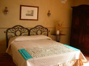 a bedroom with a bed with a white comforter at L'Atelier di Pierflavio Gallina in La Morra