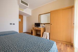 カザルボルディーノにあるHotel L'Aragostaのベッドルーム1室(ベッド1台、鏡付きデスク付)