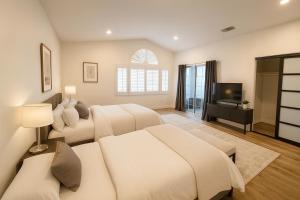 a bedroom with two beds and a flat screen tv at Venice Boardwalk Breeze 2BR - 7-min to Venice Beach in Los Angeles +10 photos