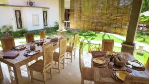 a dining room with a table and chairs and a table and chairs at Kelapa Cottage in Amed +16 photos