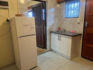 a kitchen with a white refrigerator and a sink at MAU Cottage in Krugersdorp