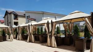 a row of tables with umbrellas and chairs at Nobel Residence in Mamaia Sat/Năvodari