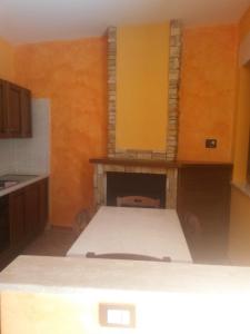 een keuken met een bed in een kamer met een open haard bij Il Borghetto Antico in Cuccaro Vetere