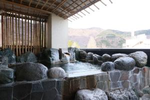 un oiseau se tenant dans une fontaine dans un mur de pierre dans l'établissement Umimoto, à Hakone