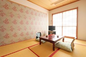 un salon avec une table et une fenêtre dans l'établissement Umimoto, à Hakone