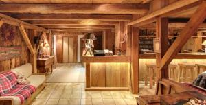 a living room with wooden walls and wooden beams at Residence Hôtelière La Renardiere in Samoëns