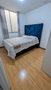 a bedroom with a bed and a wooden floor at Departamento céntrico con sala comedor y cocina in Pachacutec
