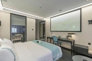 une chambre d'hôtel avec un grand écran de projection dans l'établissement Xana Hotelle Nanchang Hongdu Middle Avenue Provincial TV Station, à Nanchang County
