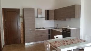 eine Küche mit Holzschränken und einem Tisch mit einem Esszimmer in der Unterkunft Appartamento Dellea in Luino