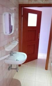 a bathroom with a sink and a red door at Pokoje do wynajęcia Stąporków in Stąporków
