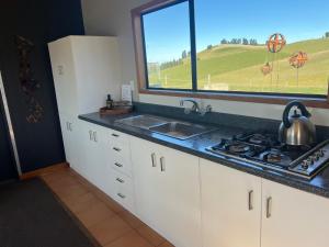 a kitchen with a sink and a stove and a window at Have it all! Off the Grid Lake Opuha in Fairlie