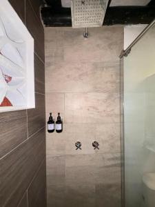 a bathroom with a shower with three bottles of wine at Hotel Hacienda Anacaona - San Agustín in San Agustín +64 photos