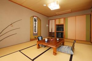 un salon avec une table et des chaises en bois dans l'établissement Umimoto, à Hakone