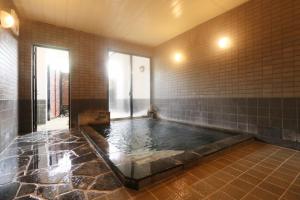 une grande salle de bains avec un bain à remous au milieu dans l'établissement Umimoto, à Hakone