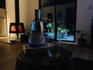 a bottle of wine sitting on a table next to a glass at Architecturally designed cabin with outdoor bathtub and fireplace in Forcett