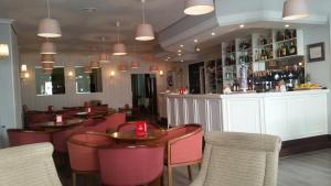 a restaurant with tables and chairs and a bar at Hotel Europa in Cambados