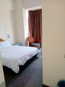 a hotel room with a bed and a chair at Costa Mahkota Two Bedroom With Balcony , Mahkota Hospital , Parade , Pahlawan in Melaka