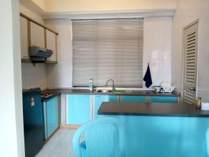 a kitchen with blue cabinets and a sink at Costa Mahkota Two Bedroom With Balcony , Mahkota Hospital , Parade , Pahlawan in Melaka +4 photos