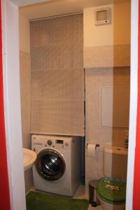 a bathroom with a washing machine and a toilet at Sunny Two-story Apartment Kyje in Prague