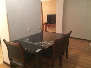 stół jadalny z 2 krzesłami i telewizor w obiekcie Apartment on Zvanba 22 w mieście Suchumi
