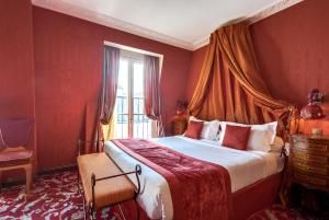 a bedroom with a large bed and a large window at La Villa Royale in Paris