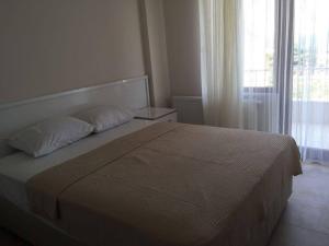 sypialnia z dużym łóżkiem i oknem w obiekcie Yasar Apart w mieście Synopa