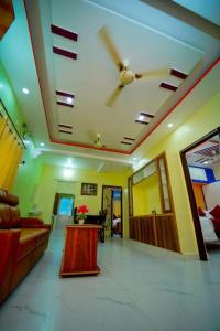 ティルパティにあるS S Homestay Luxury 2BHK and 1BHK AC Apartments Near Tirupati Railway Station and Balaji Bus Standの天井のあるリビングルーム(ソファ付)