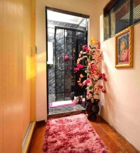 Habitación con puerta con alfombra rosa y ventana en Residencial Morumbi Hostel, en São Paulo