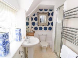 a blue and white bathroom with a toilet and a sink at Fairview Cottage in Burford +19 photos