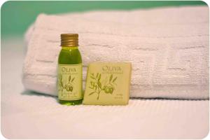 a bottle of olive oil and a soap next to towels at Hostal Oliveta in Barcelona