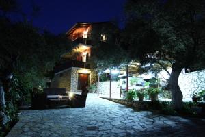 a house with a tree and a stone walkway at night at Evridiki's Villas in Agios Nikitas