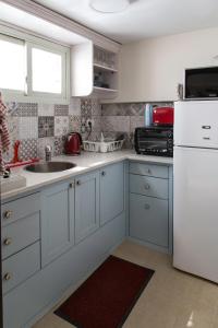 a kitchen with blue cabinets and a white refrigerator at Mark House in Nazareth