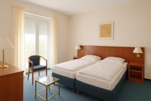 ein Hotelzimmer mit einem Bett und einem Stuhl in der Unterkunft Kleine Landvilla in Meuro