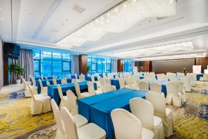un salón de banquetes con mesas azules y sillas blancas en Zhonghao International Hotel, en Hangzhou